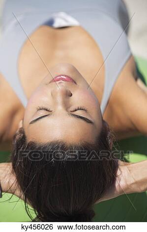 Stock Photograph - Beautiful woman exercising with fitness ball on the beach. Fotosearch
