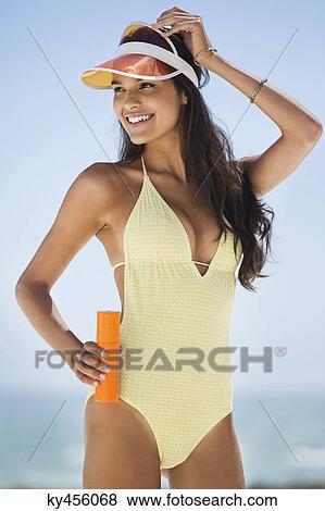 Beautiful woman holding a suntan lotion on the beach View Large Photo Image Stock Photo - Beautiful woman holding a suntan lotion on the beach. Fotosearch