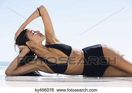 Beautiful woman in bikini posing on the beach View Large Photo Image Stock Photograph - Beautiful woman in bikini posing on the beach. Fotosearch