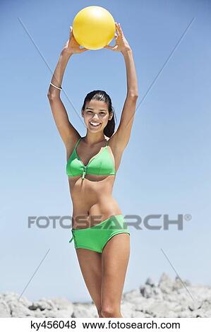 Beautiful woman playing with a ball on the beach View Large Photo Image Stock Photo - Beautiful woman playing with a ball on the beach. Fotosearch