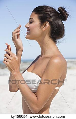 Beautiful woman smelling suntan lotion on the beach View Large Photo Image Picture - Beautiful woman smelling suntan lotion on the beach. Fotosearch