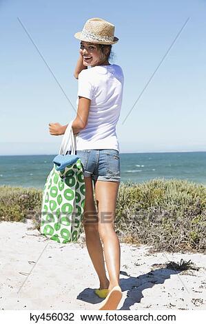 Happy woman carrying a bag on the beach View Large Photo Image Stock Image - Happy woman carrying a bag on the beach. Fotosearch