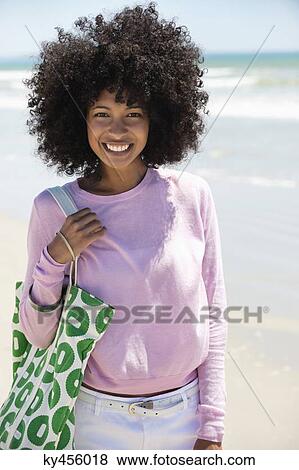 Stock Photo - Portrait of a woman smiling on the beach. Fotosearch