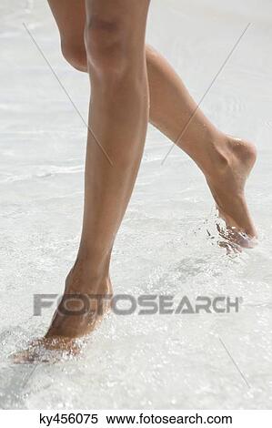 Woman walking in water on the beach View Large Photo Image Stock Photography - Woman walking in water on the beach. Fotosearch