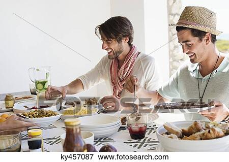 Friends eating lunch at dining table View Large Photo Image Stock Photo - Friends eating lunch at dining table. Fotosearch