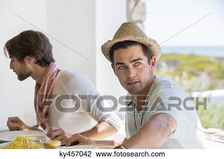 Friends sitting at a dining table having lunch View Large Photo Image Stock Image - Friends sitting at a dining table having lunch. Fotosearch