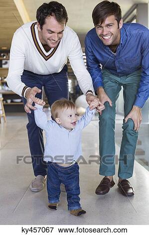 Parents helping their son to walk View Large Photo Image Stock Photo - Parents helping their son to walk. Fotosearch