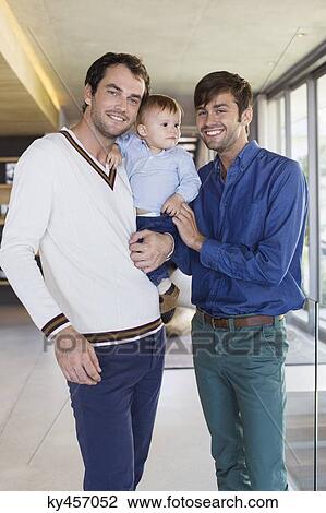 Stock Image - Parents smiling with their son at home. Fotosearch