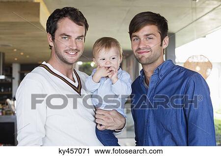 Stock Image - Parents smiling with their son at home. Fotosearch