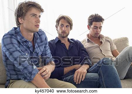 Three friends sitting together on a couch View Large Photo Image Stock Image - Three friends sitting together on a couch. Fotosearch