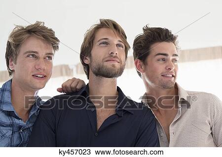 Three male friends looking away View Large Photo Image Stock Image - Three male friends looking away. Fotosearch