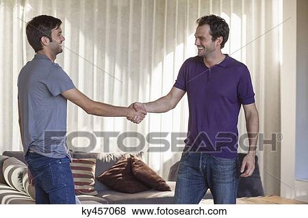 Two friends shaking hands and smiling View Large Photo Image Stock Photo - Two friends shaking hands and smiling. Fotosearch