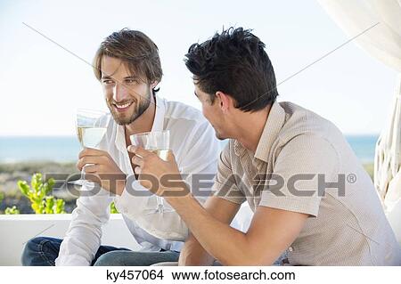 Two male friends enjoying white wine in outdoor View Large Photo Image Picture - Two male friends enjoying white wine in outdoor. Fotosearch