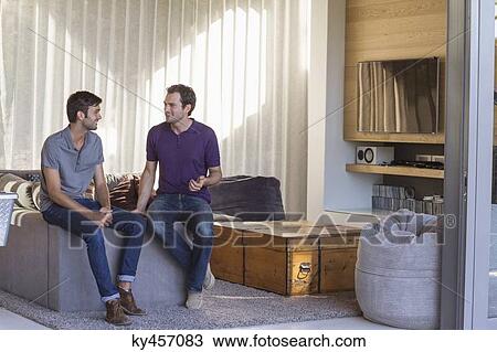 Two male friends looking each other and smiling View Large Photo Image Stock Image - Two male friends looking each other and smiling. Fotosearch