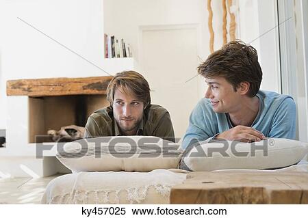 Stock Photography - Two male friends lying on the bed. Fotosearch