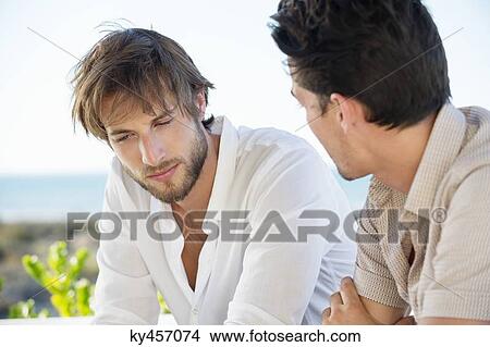 Two male friends sitting together and talking View Large Photo Image Picture - Two male friends sitting together and talking. Fotosearch