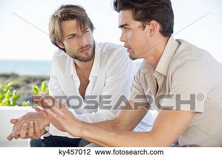 Two male friends sitting together and talking View Large Photo Image Stock Image - Two male friends sitting together and talking. Fotosearch