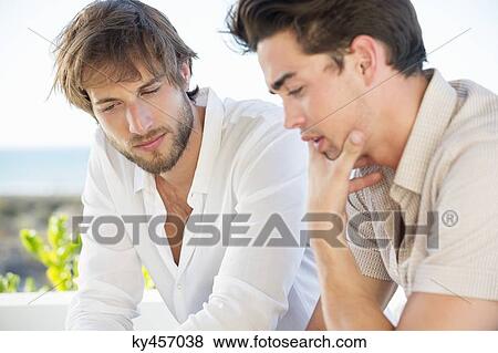 Two male friends sitting together View Large Photo Image Stock Photo - Two male friends sitting together. Fotosearch