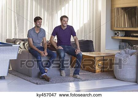 Two male friends smiling at home View Large Photo Image Stock Photo - Two male friends smiling at home. Fotosearch