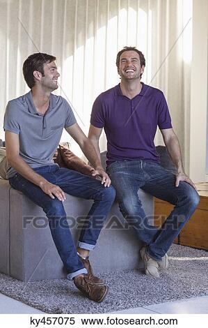 Two male friends smiling at home View Large Photo Image Stock Photography - Two male friends smiling at home. Fotosearch