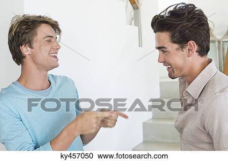 Two male friends talking to each other View Large Photo Image Stock Image - Two male friends talking to each other. Fotosearch