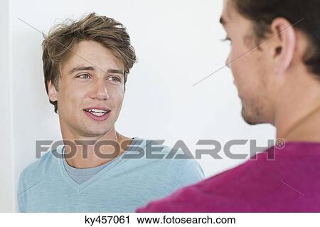 Two male friends talking to each other View Large Photo Image Stock Image - Two male friends talking to each other. Fotosearch