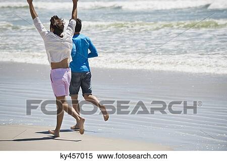 Two men running on the beach View Large Photo Image Stock Photography - Two men running on the beach. Fotosearch