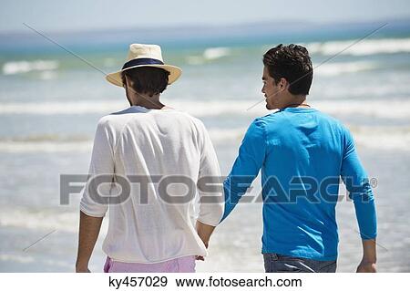 Stock Photo - Two men walking on the beach. Fotosearch