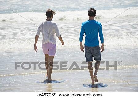 Two men walking on the beach View Large Photo Image Stock Photo - Two men walking on the beach. Fotosearch