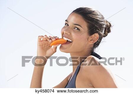 Beautiful woman eating a slice of papaya View Large Photo Image Picture - Beautiful woman eating a slice of papaya. Fotosearch