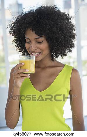 Close-up of a woman drinking mango shake View Large Photo Image Stock Photo - Close-up of a woman drinking mango shake. Fotosearch