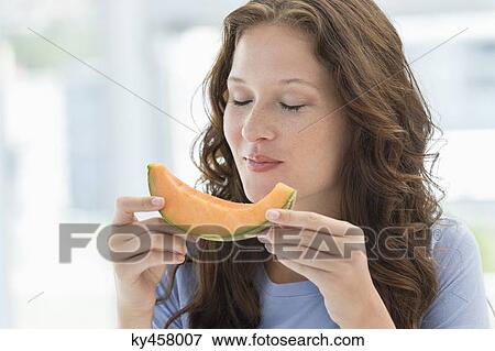 Close-up of a woman eating melon View Large Photo Image Stock Photo - Close-up of a woman eating melon. Fotosearch