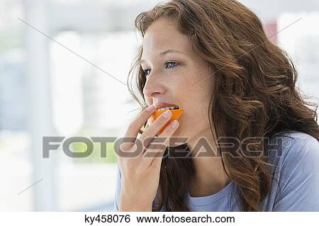 Stock Photograph - Close-up of a woman eating orange. Fotosearch