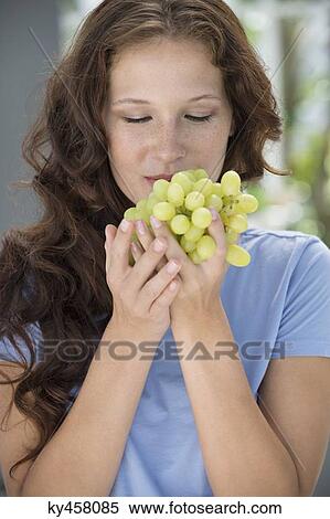 Stock Photography - Close-up of a woman smelling grapes. Fotosearch