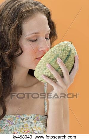 Close-up of a woman smelling melon View Large Photo Image Stock Photo - Close-up of a woman smelling melon. Fotosearch