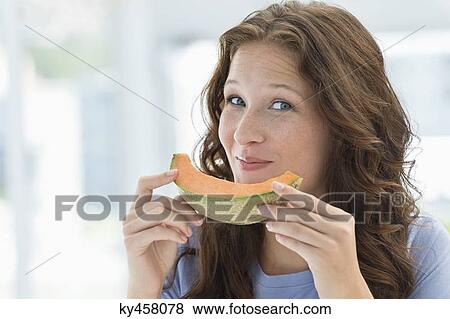 Portrait of a smiling woman eating melon View Large Photo Image Stock Photo - Portrait of a smiling woman eating melon. Fotosearch