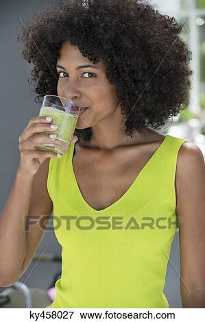 Portrait of a woman drinking kiwi shake View Large Photo Image Stock Photo - Portrait of a woman drinking kiwi shake. Fotosearch