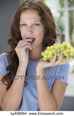 Portrait of a woman eating grapes View Large Photo Image Picture - Portrait of a woman eating grapes. Fotosearch