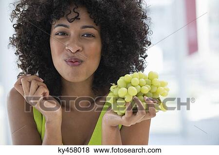 Portrait of a woman eating grapes View Large Photo Image Stock Photo - Portrait of a woman eating grapes. Fotosearch