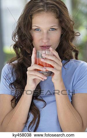 Portrait of a woman holding a glass of orange juice View Large Photo Image Stock Photo - Portrait of a woman holding a glass of orange juice. Fotosearch