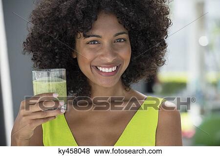 Portrait of a woman holding a glass of kiwi juice View Large Photo Image Stock Photo - Portrait of a woman holding a glass of kiwi juice. Fotosearch