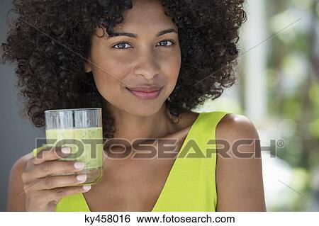 Portrait of a woman holding a glass of kiwi juice View Large Photo Image Stock Photograph - Portrait of a woman holding a glass of kiwi juice. Fotosearch