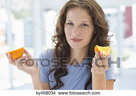Portrait of a woman holding an orange View Large Photo Image Picture - Portrait of a woman holding an orange. Fotosearch