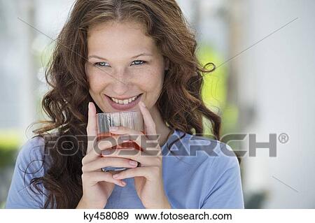 Smiling woman drinking orange juice View Large Photo Image Stock Photo - Smiling woman drinking orange juice. Fotosearch