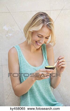 Smiling woman eating avocado View Large Photo Image Stock Photography - Smiling woman eating avocado. Fotosearch