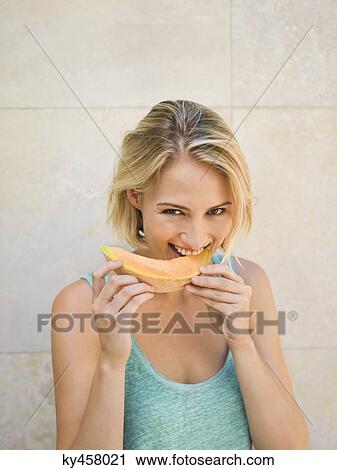 Smiling woman eating melon View Large Photo Image Stock Image - Smiling woman eating melon. Fotosearch