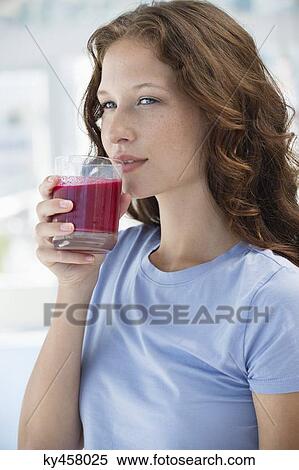 Woman holding a glass of pomegranate juice View Large Photo Image Stock Photography - Woman holding a glass of pomegranate juice. Fotosearch