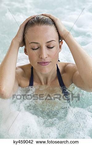 Stock Image - Beautiful woman in a hot tub. Fotosearch