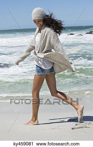 Beautiful woman walking on the beach in winter View Large Photo Image Stock Image - Beautiful woman walking on the beach in winter. Fotosearch