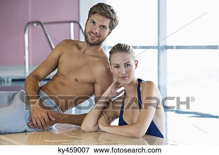 Stock Photo - Smiling couple at the poolside. Fotosearch